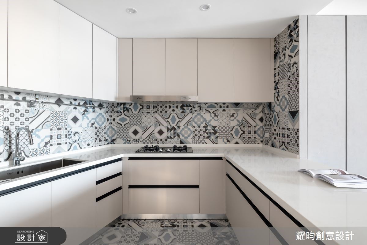 廚房壁面與地坪鋪陳馬賽克磚，搭配消光暖灰色櫃體，呼應整體淡雅色調。