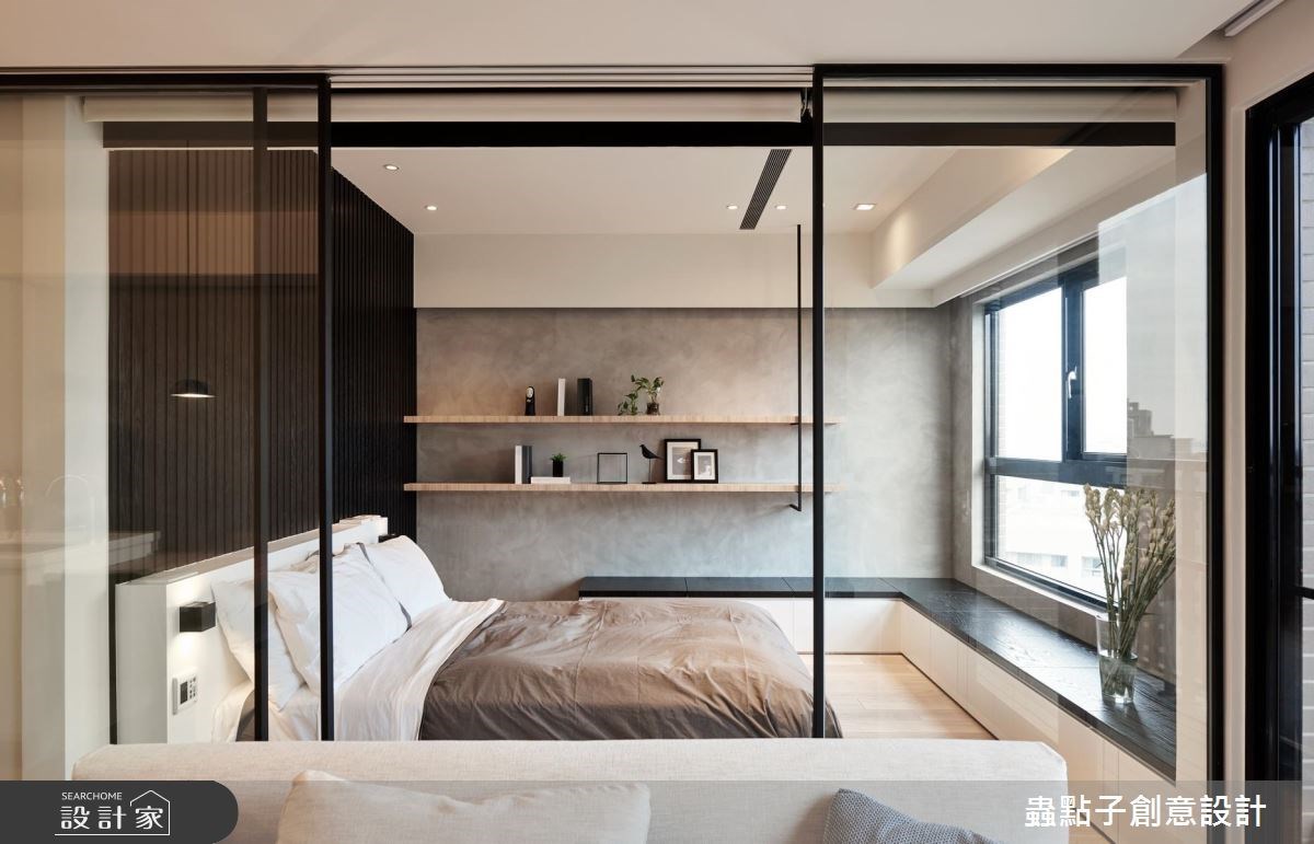 僅有 18 坪的住宅利用玻璃門片作為公私領域的隔間，臥室內也盡量將設計做到極簡維持寬敞感，層板打造的牆面收納能擺放幾本睡前讀物。
