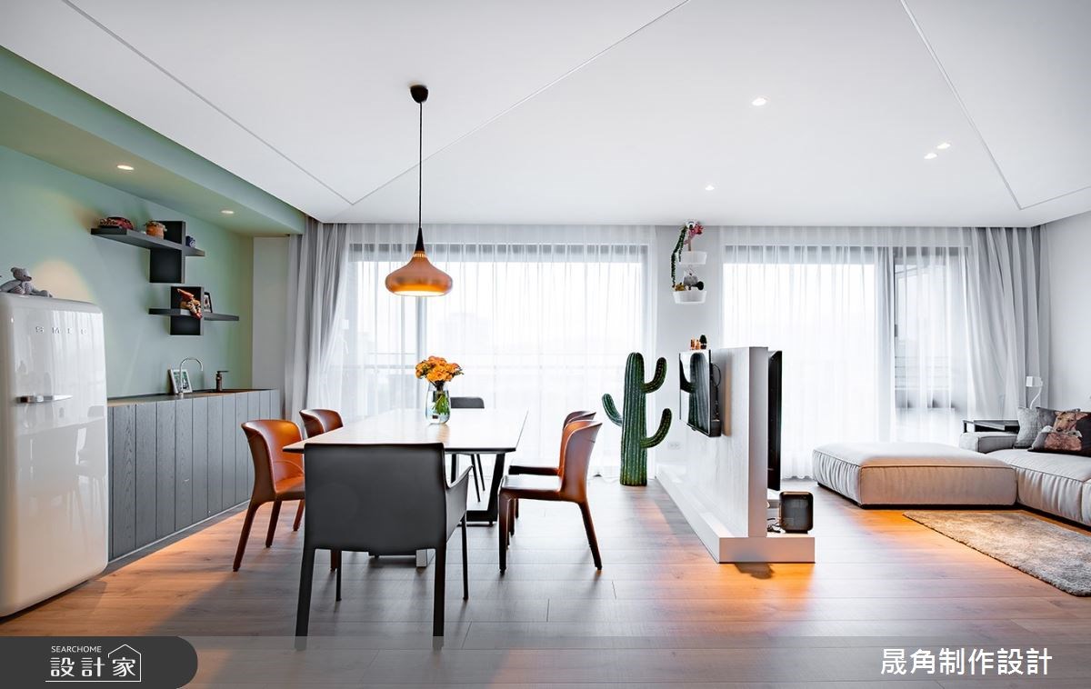 一道半高電視牆將客廳一分為二，讓廳區與用餐空間都能獲得充足的自然採光。