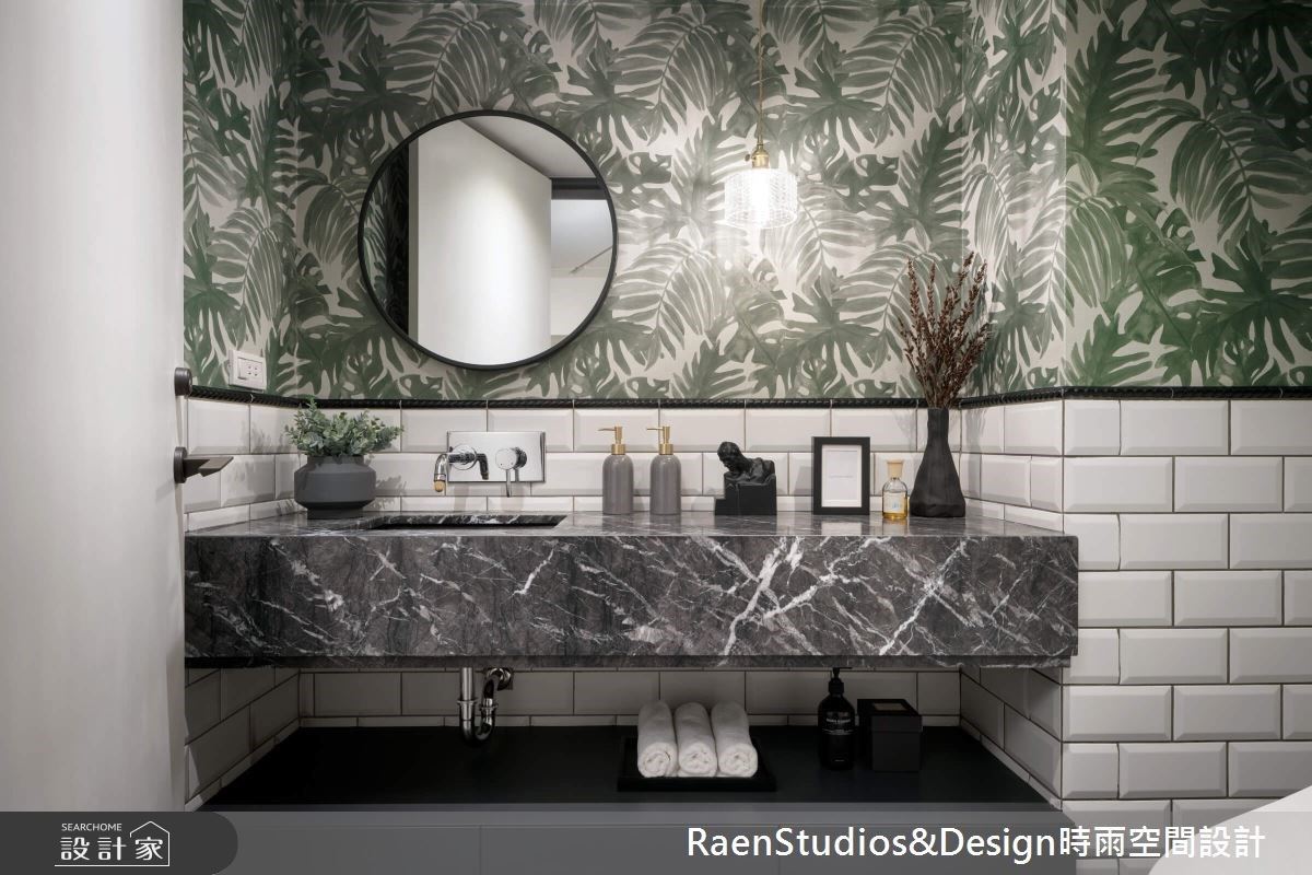 客浴有別於其他領域的素淨，挑選丹麥的進口壁紙拼接鐵道磚，綠意盎然的圖騰充滿生命力，並以黑框圓鏡、黑線元素加強了個性氛圍，成為一樓空間的亮點。