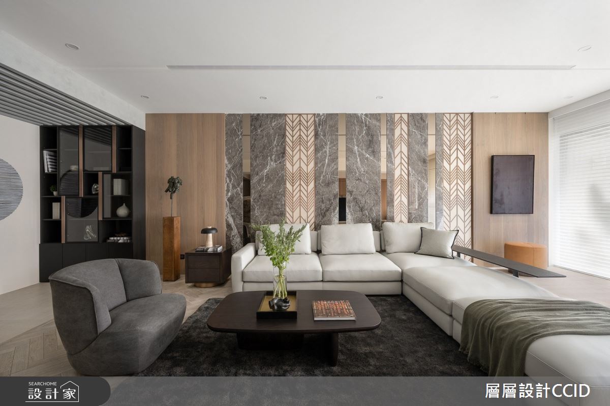 沙發背牆藉由木紋和石材堆疊，提升視覺層次感，型塑內斂、靜謐的居家氛圍。