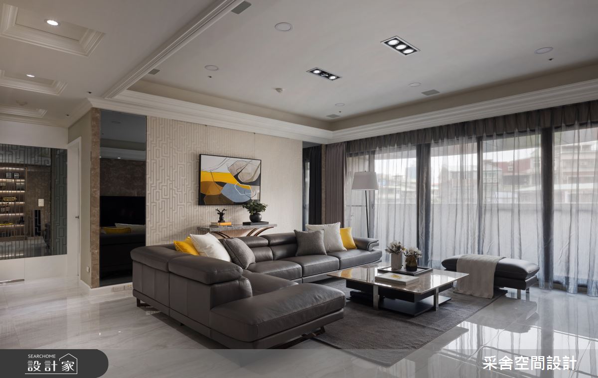 沙發背牆以柔美線條，勾勒視覺層次，並結合對稱灰鏡，挹注典雅氛圍。