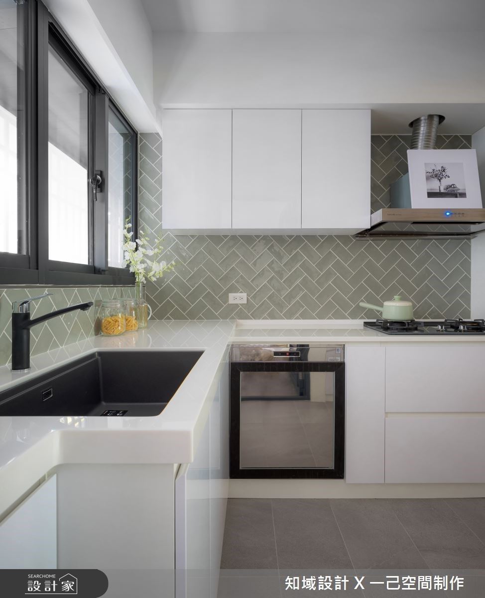廚房以白色櫃體搭配綠色鐵道磚，延續低彩度設計呼應整體清爽北歐調性。