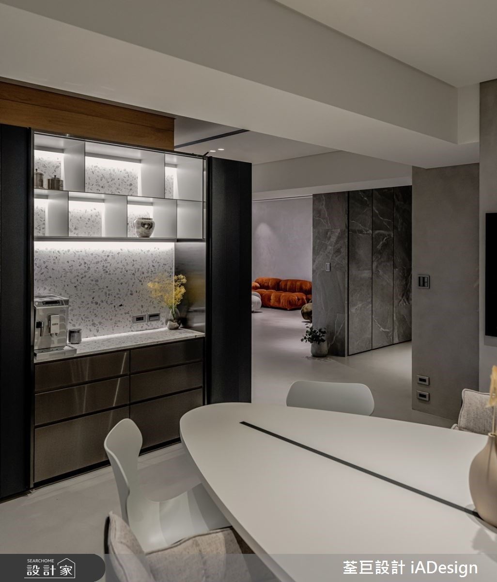 餐具櫃延續客廳區櫃體主題，以磨石子和鍍鈦金屬，使公領域空間有一致性。