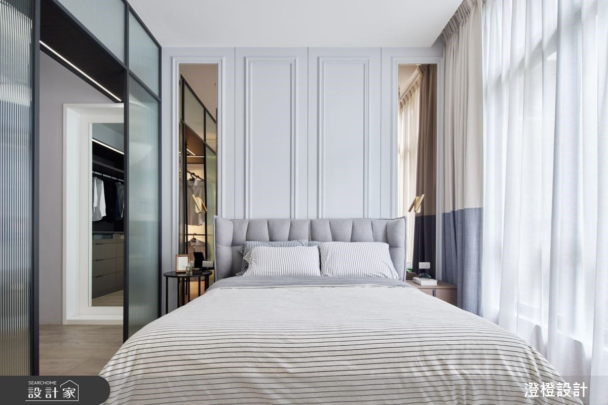 主臥室延續公領域的線板元素，在床頭打造美式氛圍感，兩旁使用造型壁燈和茶鏡增加視覺俐落感。