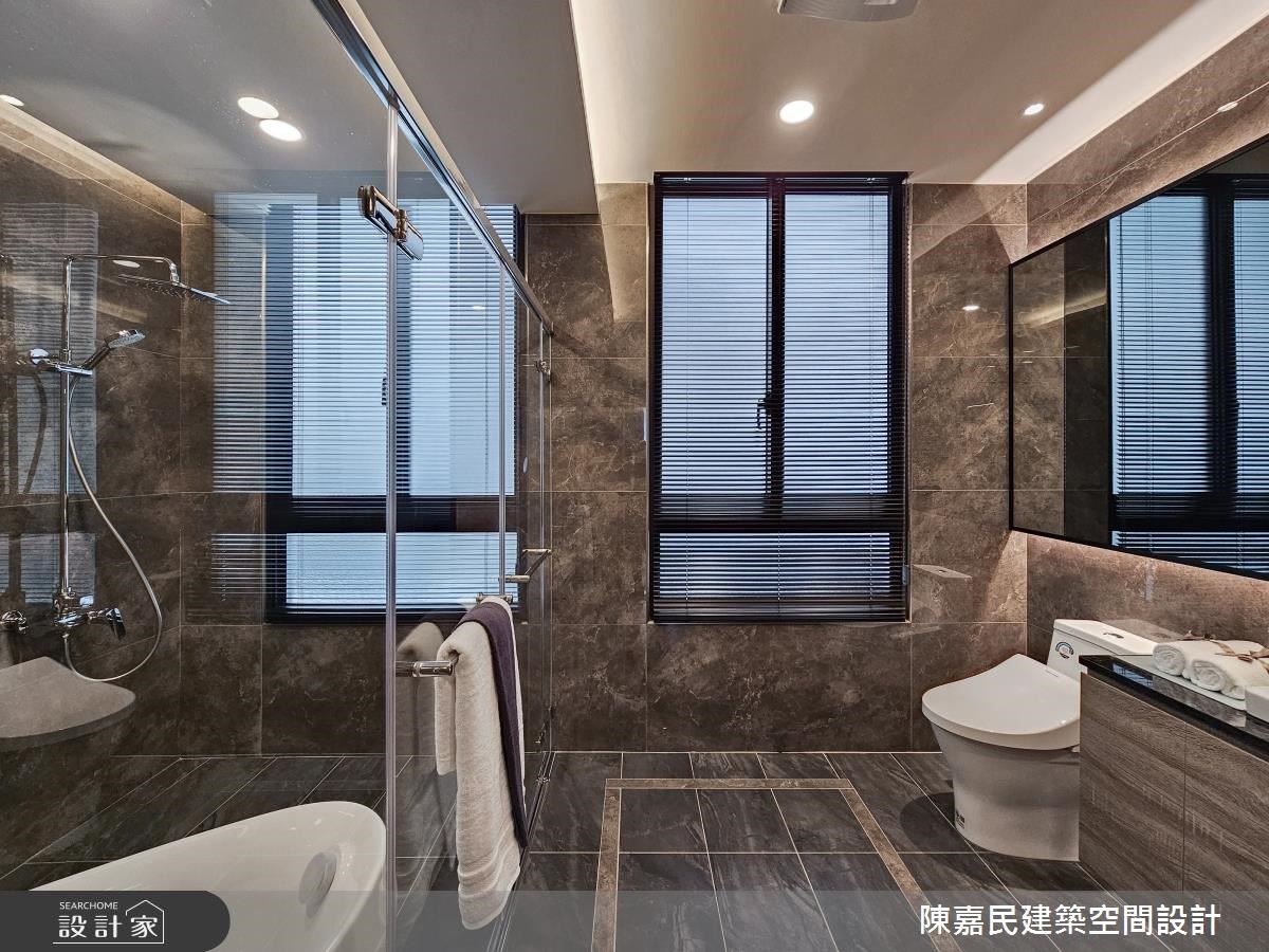主衛浴以深色磁磚加上灰鏡與明鏡搭配的鏡櫃，呈現飯店風的精品感。