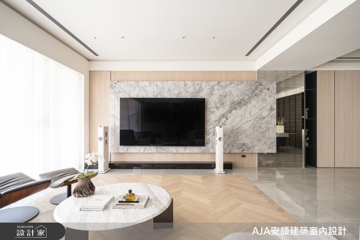電視牆使用大面積石材營造大器的氣勢感，下方的襯托木皮加上間接照明的燈光設計，勾勒出線條感，強化電視牆面的層次效果。