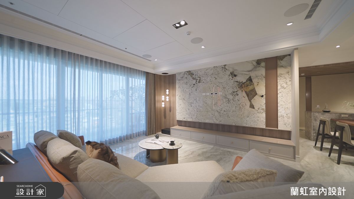 奧德賽石材製成電視牆與木皮的搭配，讓立面呈現不張揚的奢華氣質。