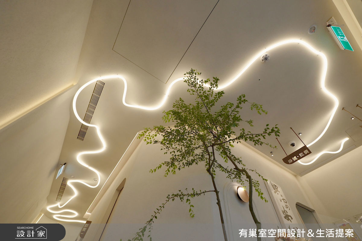 蜿蜒線型燈一路延伸至走廊,串聯空間視線,也放大診所的視覺尺度。