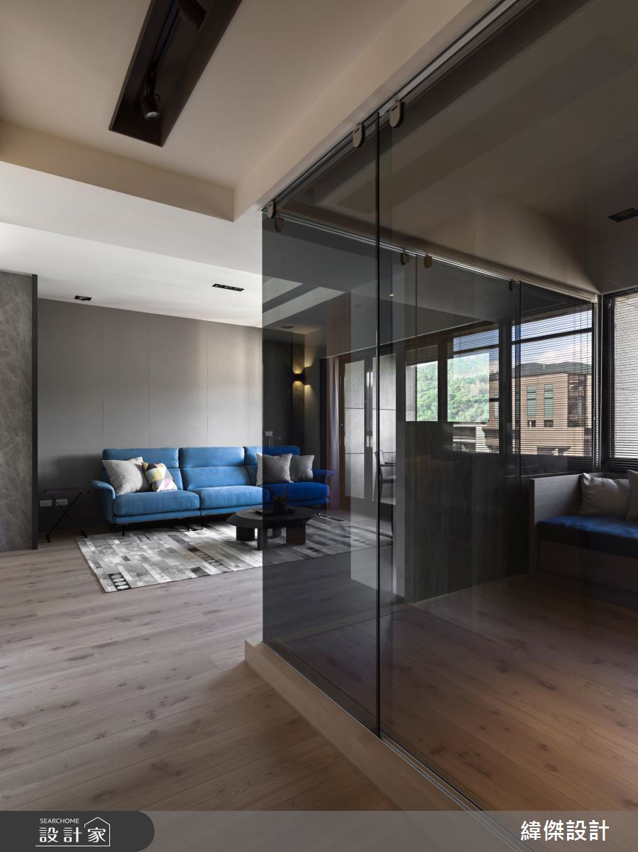 客廳與一旁的起居室採用了暗色玻璃做出隔間，不論當作客房或書房均可，加上採光得宜，空間顯得簡約通透。